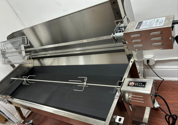 Stainless steel barbecue grill with rotisserie system on a wooden floor.
Add-On Skewer Kit displayed, showing the skewer, forks, bracket, and motor for large rotisserie models.