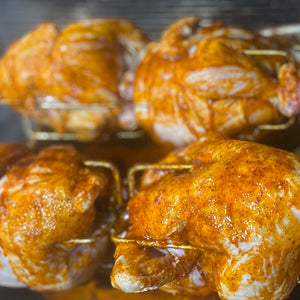Whole chickens roasting on a Cyprus foukou charcoal rotisserie grill with stainless steel skewers, perfect for Greek souvla and kontosouvli style BBQ queens ny